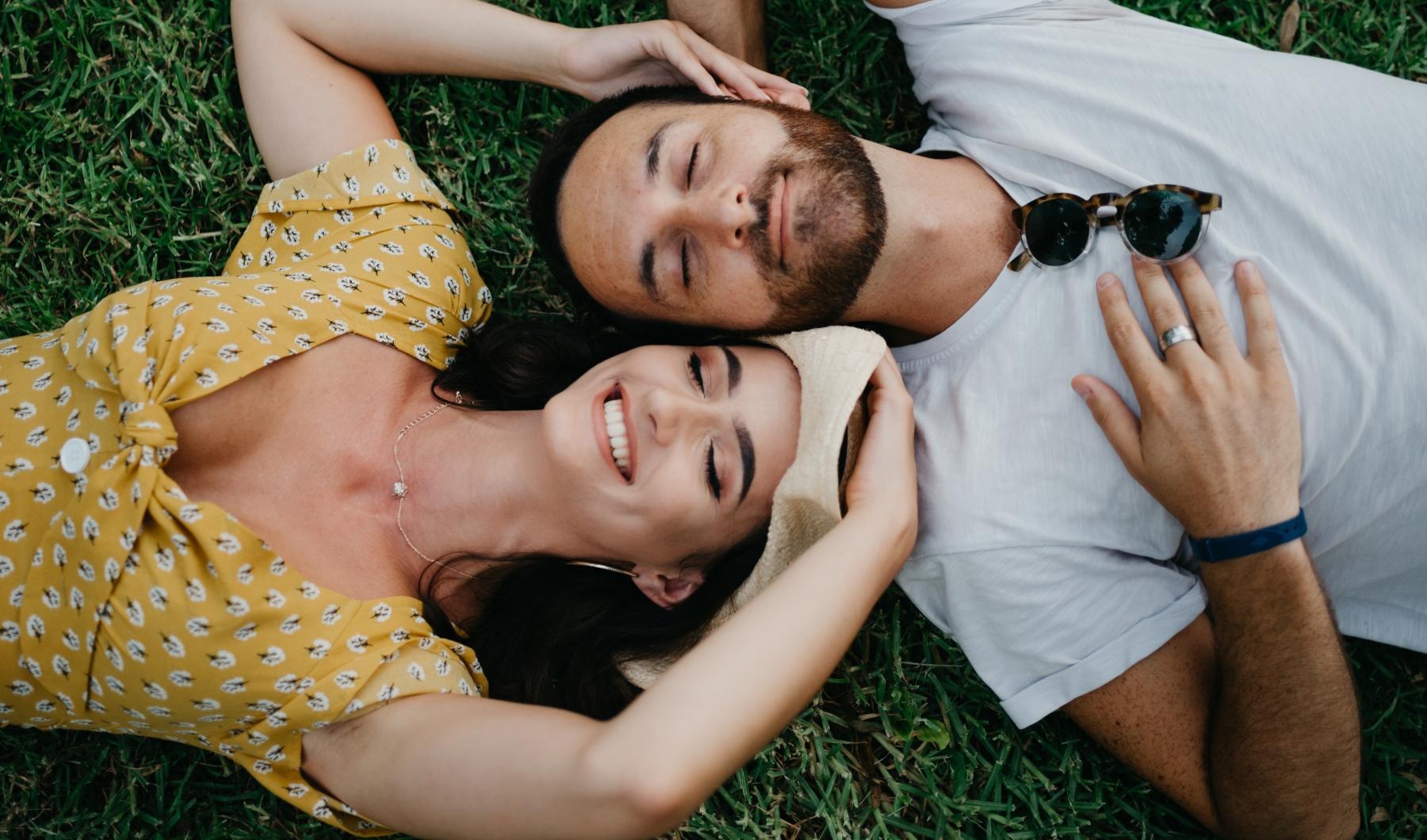 a man and woman lying in the grass