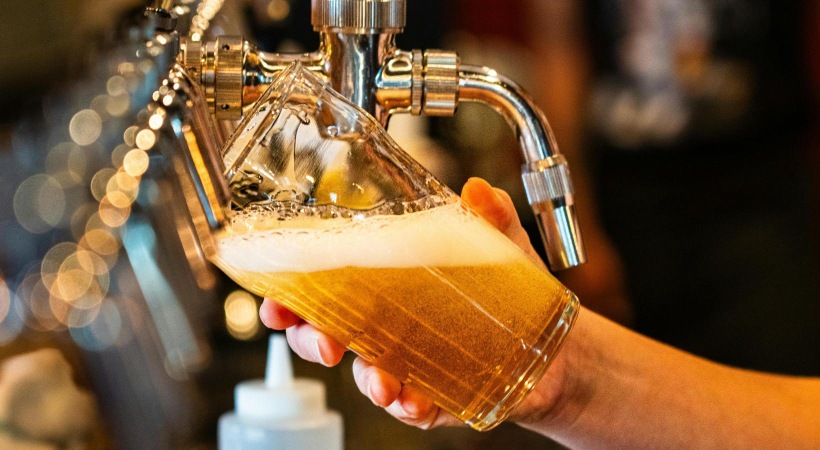 man pouring beer from a tap