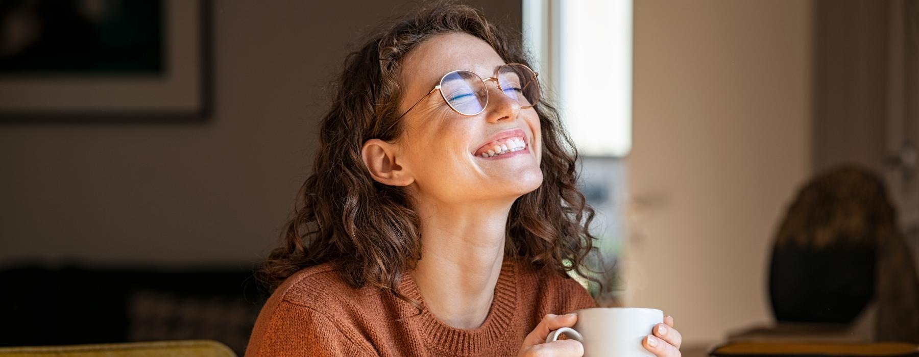 a woman wearing glasses and holding a cup